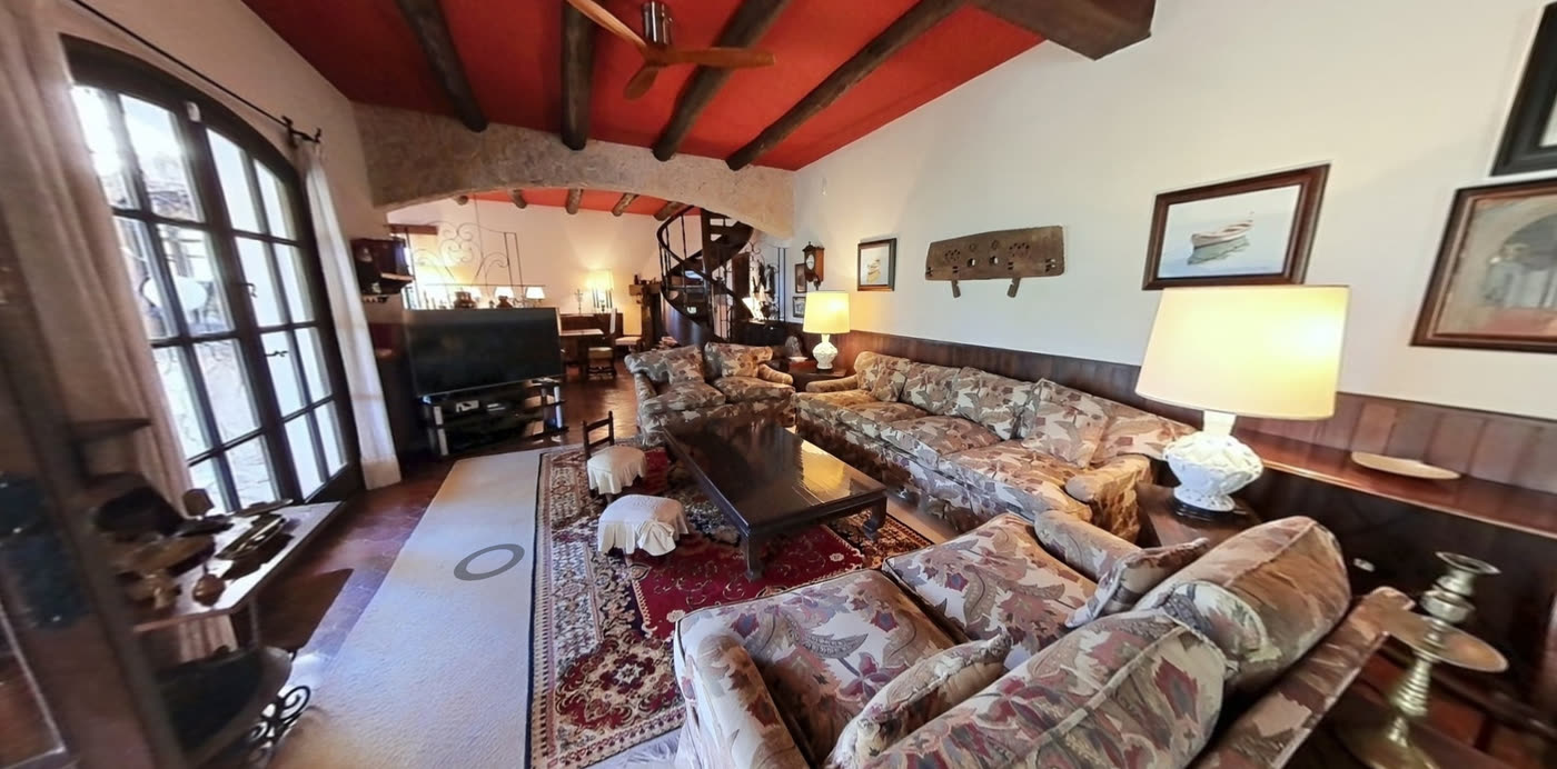 Salón con techo de vigas rojas, chimenea y sofás