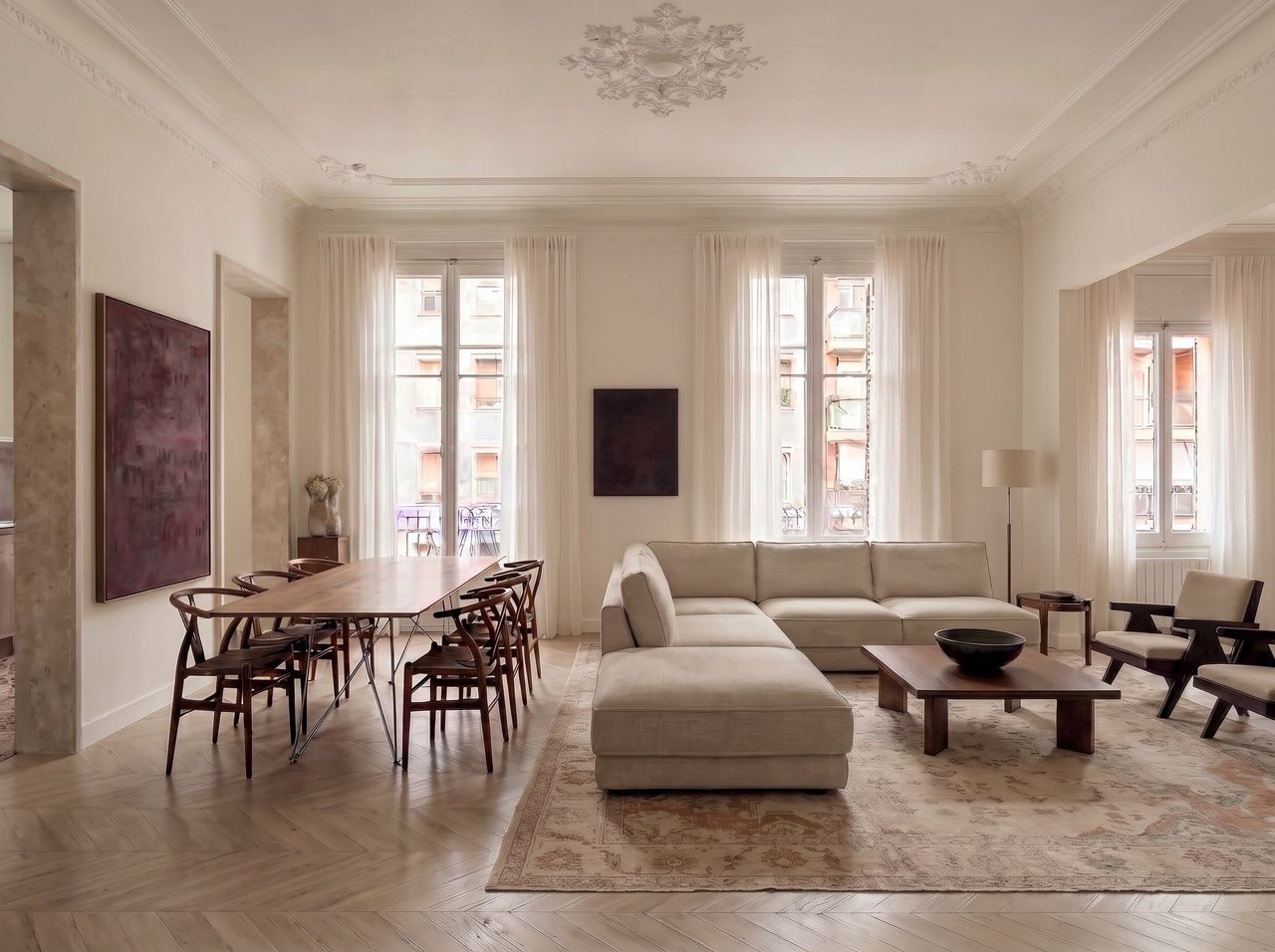 Salón del piso de Sant Gervasi, con parquet de roble en espiga, molduras restauradas en el techo y balcones a la calle